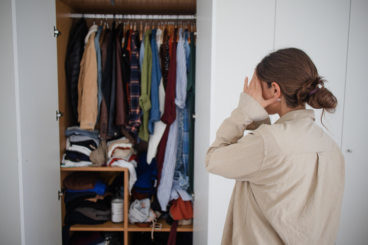Overwhelmed Woman in Front of Cluttered Wardrobe
