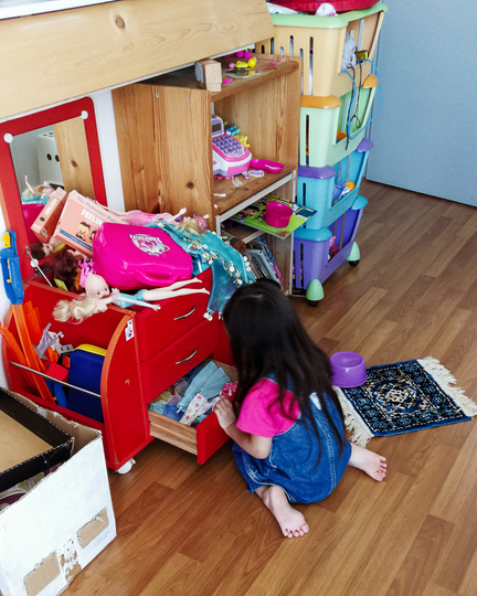 Indoor Portrait of a Child Playing in a Very Messy Room, Looking